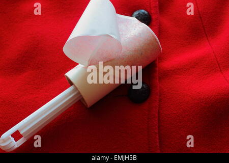 White piccoli rulli di lanugine pulire coat rosso Foto Stock