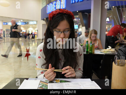 Adolescente che stanno curiosando menu al ristorante giapponese nel centro commerciale per lo shopping Foto Stock