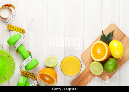 Agrumi, metro a nastro e manubri. Arance, cedri e limoni. Cibo sano. Su tavola di legno con uno sfondo con spazio di copia Foto Stock