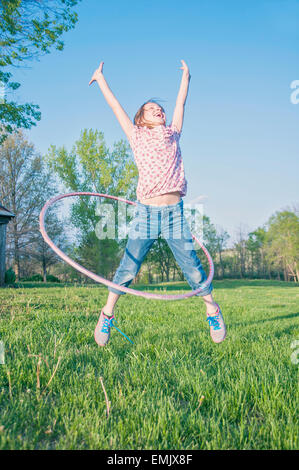 Ragazza jumping con hula hoop Foto Stock