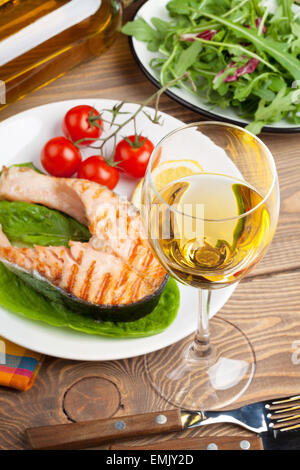 Salmone alla griglia e vino whtie sul tavolo di legno Foto Stock