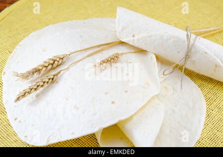 Mazzetto di tortillas e un bastone di grano su una tovaglia di colore giallo Foto Stock