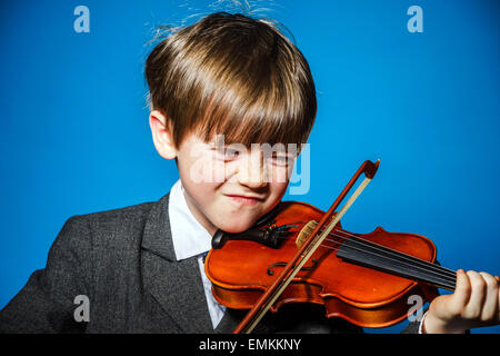 I capelli rossi preschooler ragazzo con violino, isolato sul blu, il concetto di musica Foto Stock