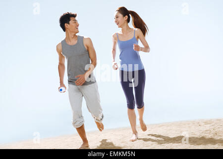Le coppie romantiche in esecuzione sulla spiaggia Foto Stock