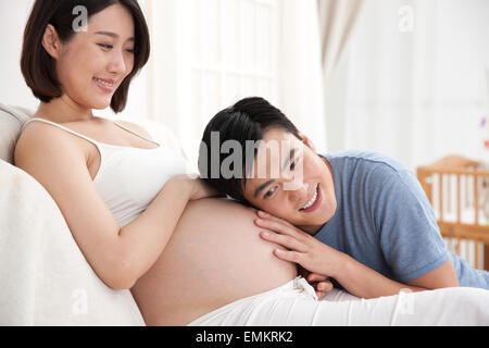 Il giovane padre remò incinta pancia per ascoltare il feto Foto Stock