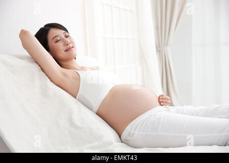 Donne in stato di gravidanza il riposo a letto Foto Stock