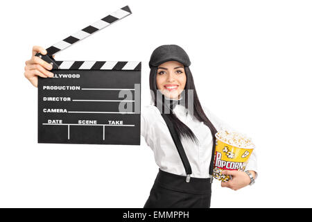 Femmina giovane regista cinematografica tenendo un filmato battaglio board e una scatola di popcorn isolati su sfondo bianco Foto Stock