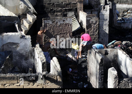 Quezon City, Filippine. 22 apr, 2015. Ricerca residenti per i loro averi in bruciato case dopo un incendio in una delle baraccopoli in Quezon City, Filippine, il 22 aprile 2015. Il fuoco a sinistra una donna anziana morti e 150 famiglie senza tetto. © Rouelle Umali/Xinhua/Alamy Live News Foto Stock