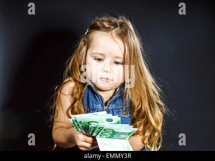 Carino bambina con denaro euro nella sua mano. Il concetto di business. Quanto costa per essere felice. Foto Stock