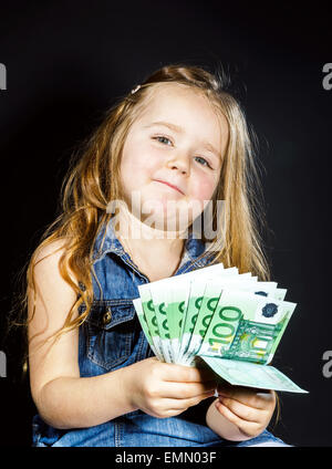 Carino bambina con denaro euro nella sua mano. Il concetto di business. Quanto costa per essere felice. Foto Stock