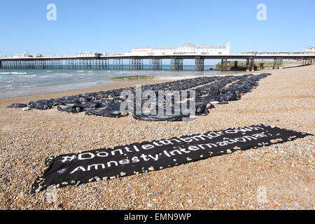 Brighton, Regno Unito. Il 22 aprile, 2015. Gli attivisti prendere parte a una manifestazione organizzata da Amnesty International per evidenziare della risposta britannica per la rapida escalation della crisi migranti nel Mediterraneo, al molo di Brighton. 200 corpo nero borse sono stati allineati sulla spiaggia e i sostenitori sono stati zippati. Credito: Randi Sokoloff/Alamy Live News Foto Stock