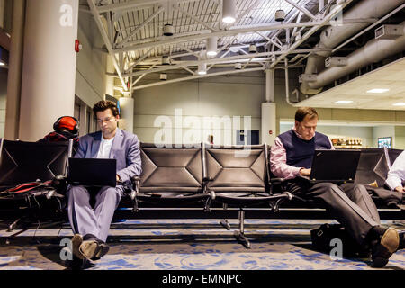 Carolina del Nord,Sud,Charlotte,Charlotte Douglas International Airport,CLT,terminal,gate,uomo uomo maschio,laptop,using,NC150225021 Foto Stock