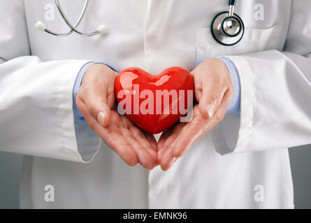 Medico tenendo cuore con cura Foto Stock