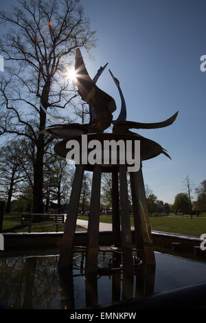 Il Cigno fontana in Bancroft Gardens vicino al Royal Shakespeare Theatre di Stratford-upon-Avon, mostrato in silhouette con su Foto Stock