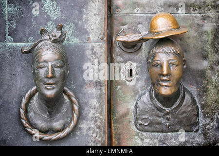 La porta di bronzo con la testa di una donna e un uomo come una manopola dello sportello a Magdeburgo, Germania Foto Stock