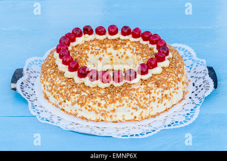 Corona di Francoforte la torta con le ciliegie su un legno di colore blu Foto Stock