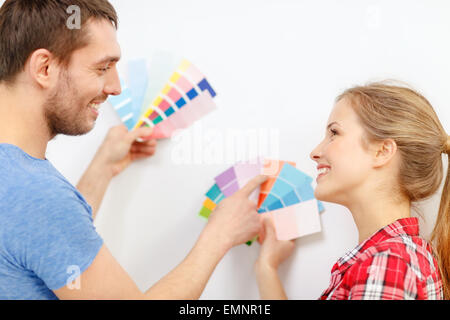 Coppia sorridente guardando i campioni di colore sono a casa Foto Stock