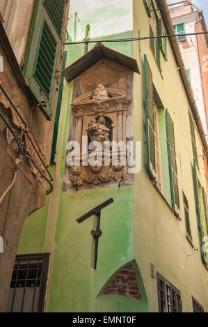 Via del centro storico di Genova, vista su una madonna situata in una nicchia all'angolo di un palazzo medievale nel centro storico (centro storico), Genova, Italia Foto Stock