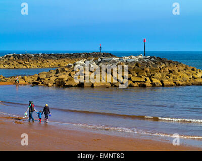 Famiglia di camminare sulla spiaggia a Sidmouth un popolare resort per vacanze su Jurassic Coast in South Devon England Regno Unito Foto Stock