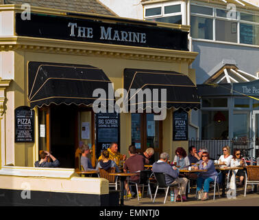 I clienti gustando un drink nella luce del sole al di fuori del pub marino a Sidmouth una piccola località balneare nel South Devon England Regno Unito Foto Stock