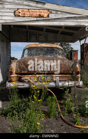 Vecchia abbandonata la stazione di benzina con una Plymouth Belvedere degli anni cinquanta auto e due pompe di benzina, di marciume sul piazzale. Ormondville, Foto Stock