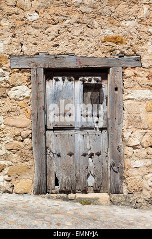 Rustico in legno vecchio porta in una facciata in muratura Foto Stock