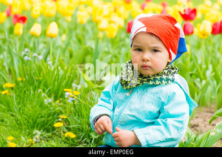 Bellissima bambina su un campo di tulipani Foto Stock