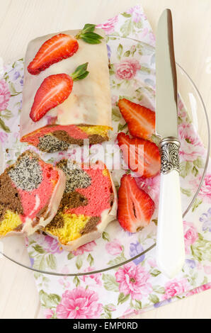 Fragola semi di papavero torta di cioccolato bianco smalto sulla lastra di vetro per la Festa della mamma. Coltello successivo e fette di strawberri fresco Foto Stock