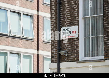 Baker Street segno apposto sul mattone scuro muro accanto al tubo di drenaggio e la finestra vuota. Ci sono altre finestre degli edifici nel blu Foto Stock