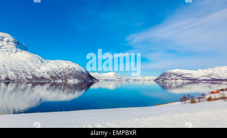 Un soleggiato paesaggio norvegese con profondo blu del cielo e snowy mountain range. Foto Stock