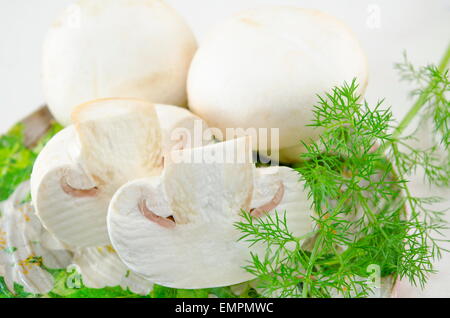 Materie di funghi freschi e rosmarino su un tagliere Foto Stock