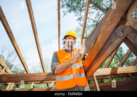 Ritratto di lavoratore il taglio di legno con handsaw presso il sito Foto Stock