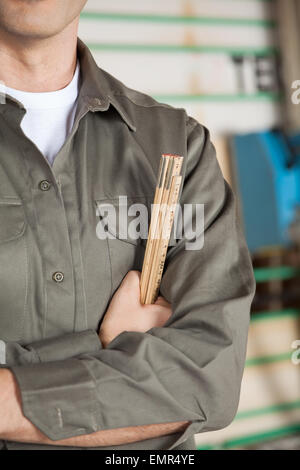 Immagine ritagliata di carpenter con righello di contenimento Foto Stock