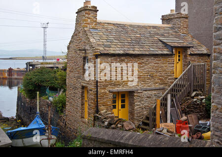 Fisherman's cottage di ardesia sul porto con il suo scalo, Stromness, Orkney Islands, Scozia Foto Stock