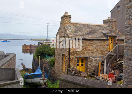 Fisherman's cottage di ardesia sul porto con il suo scalo, Stromness, Orkney Islands, Scozia Foto Stock