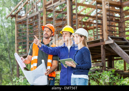 Architetto spiegare qualcosa ai colleghi in costruzione sit Foto Stock