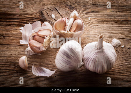 Bulbi di aglio e chiodi di garofano sul tavolo di legno, primo piano Foto Stock