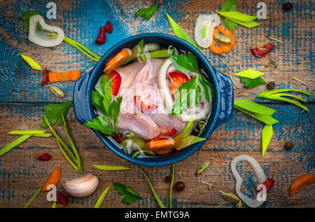 Pernice freschi in una pentola con le verdure sul vecchio tavolo in legno Foto Stock