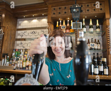 Un barista tirando una pinta in un pub Foto Stock