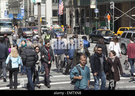 Il sempre occupato angolo della Quinta Avenue e la 42th Street in midtown Manhattan su una soleggiata giornata di primavera. Foto Stock