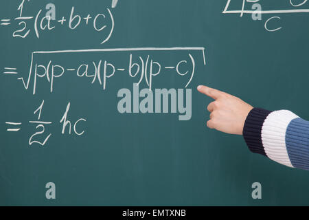 Partecipante di risolvere problemi matematici scritti in gesso sulla lavagna Foto Stock