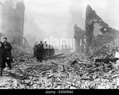 La città di Coventry, avvolto in un mantello di fumo e la pioggerella come persone vagato in giro in un daze tenendo la distruzione intorno a loro dopo il raid aereo del XIV Novembre 1940. Durante il raid della Luftwaffe era sceso 30.000 bombe incendiarie, 50 Foto Stock