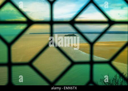 Una vista attraverso una finestra al famoso Mont St Michel abbey in Francia. Foto Stock