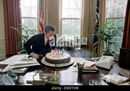 Il presidente statunitense Ronald Reagan si brucia le candeline sulla torta mentre celebra la sua festa di compleanno nell'Ufficio Ovale della Casa Bianca il 5 febbraio 1982 a Washington, DC. Foto Stock