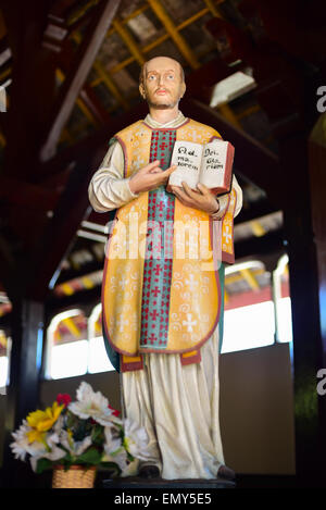 Statua di Sant'Ignazio di Loyola che mostra un libro con la frase latina scritta all'interno, alla chiesa di Sant'Ignazio Loyola a Sikka, Isola di Flores, Indonesia. Foto Stock