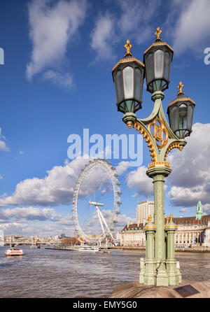 Una lampada standard sul Westminster Bridge con il London Eye e County Hall in background. Foto Stock