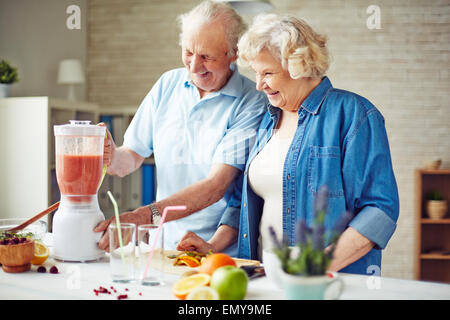 Affettuosa coppia senior rendendo frullato di frutta Foto Stock