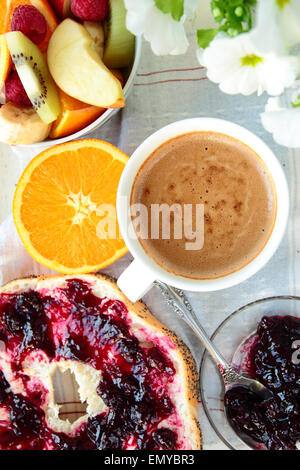 Rotolo con marmellata, fette di arancia e caffè per la prima colazione Foto Stock