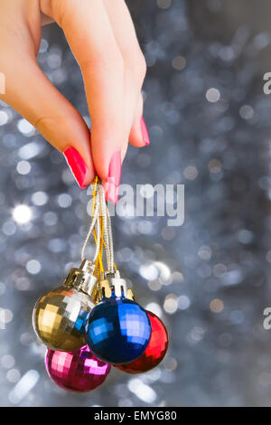 Donna mano azienda palle di Natale su sfondo bekeh con co Foto Stock