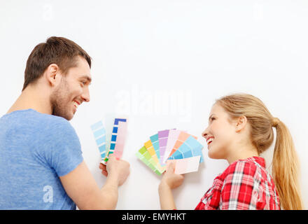 Coppia sorridente guardando i campioni di colore sono a casa Foto Stock